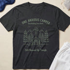 Black t-shirt with 'One Anxious Camper' graphic and text on a beige background